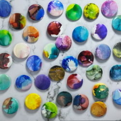 Many multi-colored and randomly designed buttons made from alcohol ink